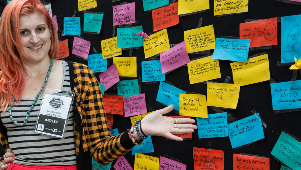 Consultations: A woman is standing in front of a wall covered in coloured stickies