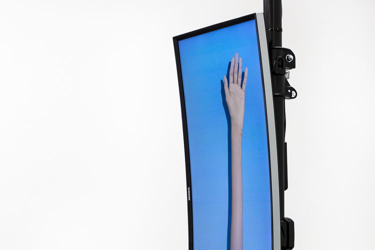 Image of an artwork with a hand and arm on a TV screen