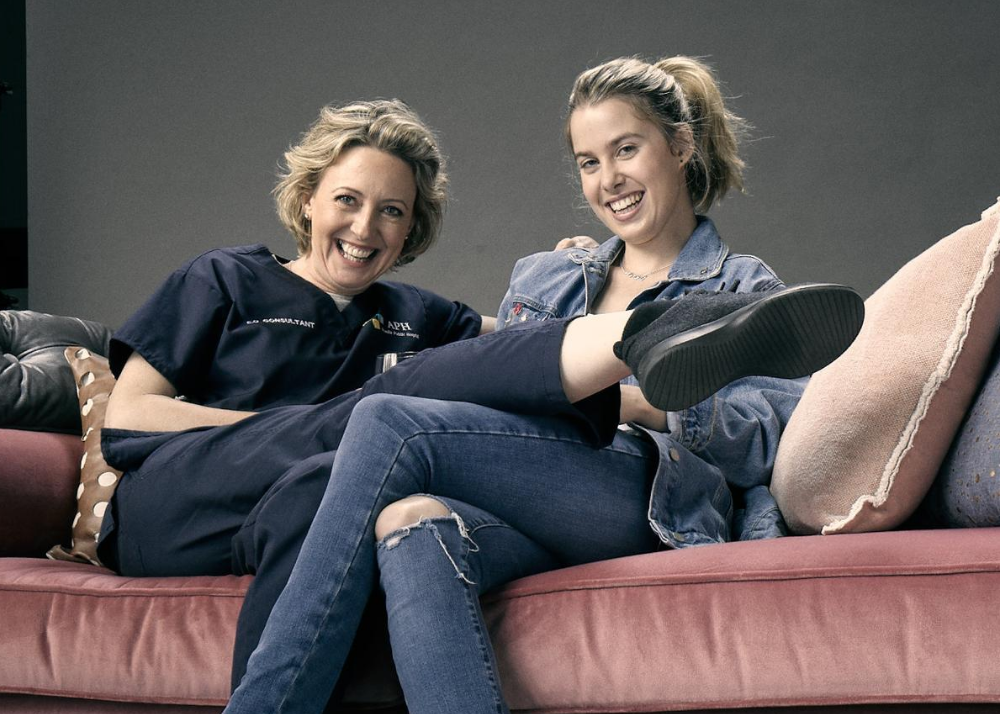 Image shows a photograph of actors Bridie McKim and Roz Hammond on a sofa.